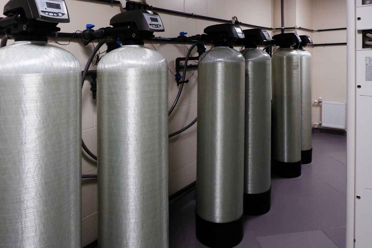 several water softener filters for water stand in a row